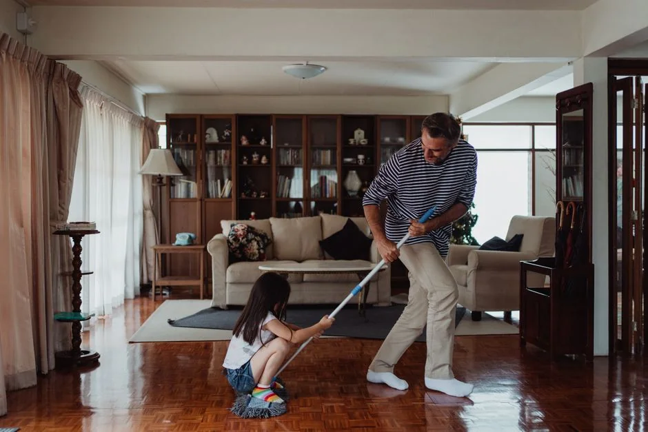 services-04 a-woman-in-a-green-shirt-and-black-gloves-vacuuming-a-gray-ottoman-5txz228u4eo